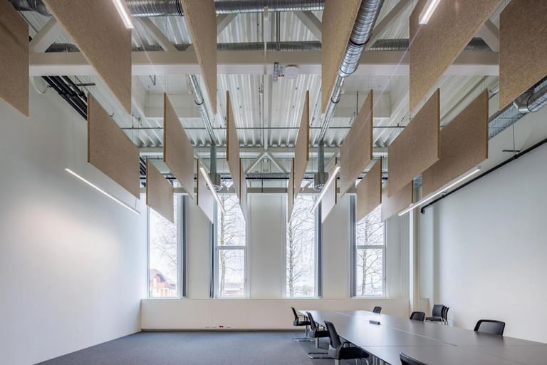 Lichtdurchfluteter Konferenzraum mit schwebenden Hanfpaneelen unter der Decke
