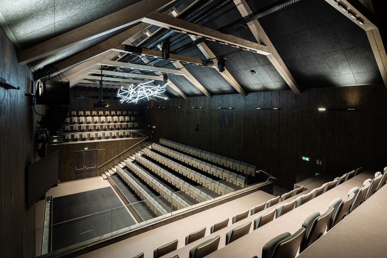 Auditorium von oben mit Spitzdach und Deckenlichtern