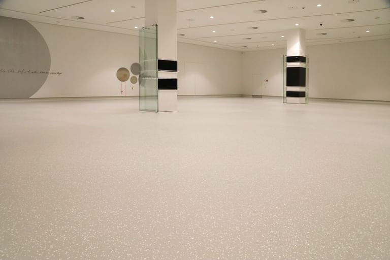 Moderner Ausstellungsraum mit weißen Wänden und Bodenbeschichtung im Schlossmuseum Linz