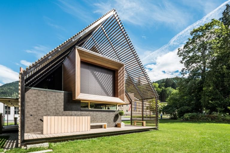 Außenansicht eines modernen Passivhauses mit Holzfassade in natürlichem Grauton, großen Fensterflächen und flach geneigtem Dach, aufgenommen bei Tageslicht im Rahmen der NÖ Landesausstellung in Neubruck, Scheibbs.