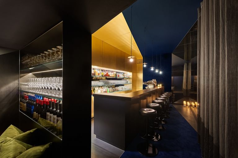 Goldene Bar im gedimmten Licht mit schwarzen Barhockern
