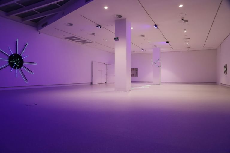 Moderner Ausstellungsraum mit weißen Wänden und Bodenbeschichtung im Schlossmuseum Linz