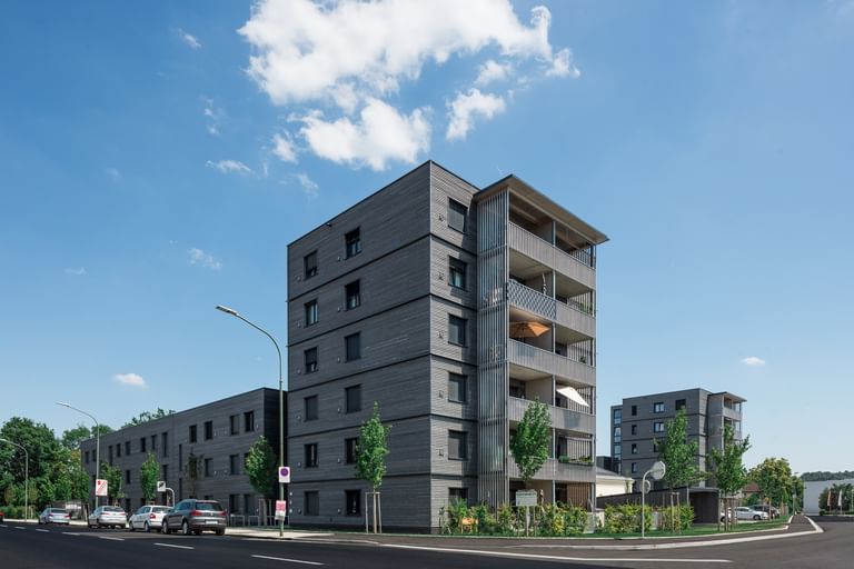 Wohngebäude von außen mit davorstehenden parkenden Autos