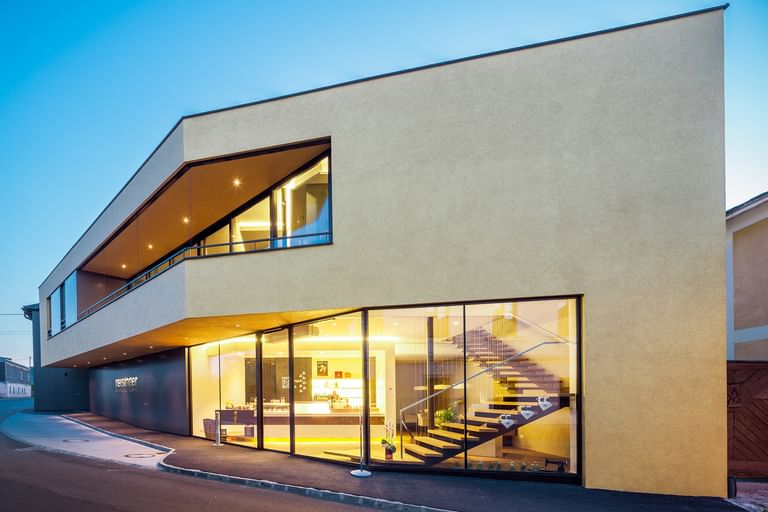 Modernes Gebäude der Bäckerei Reisinger in Gutau mit großzügigen Glasfronten und einer Fassadengestaltung mit CapaGold.