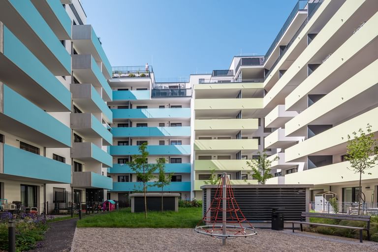 Innenhof von mehrstöckigen Wohnbauten in Wien Brigittenau mit zweifärbiger Fassade