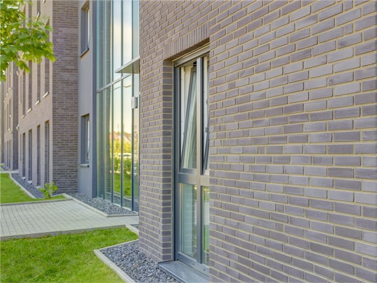 Helle Fassaden mit feinem Steindetail – klar, freundlich und modern inszeniert